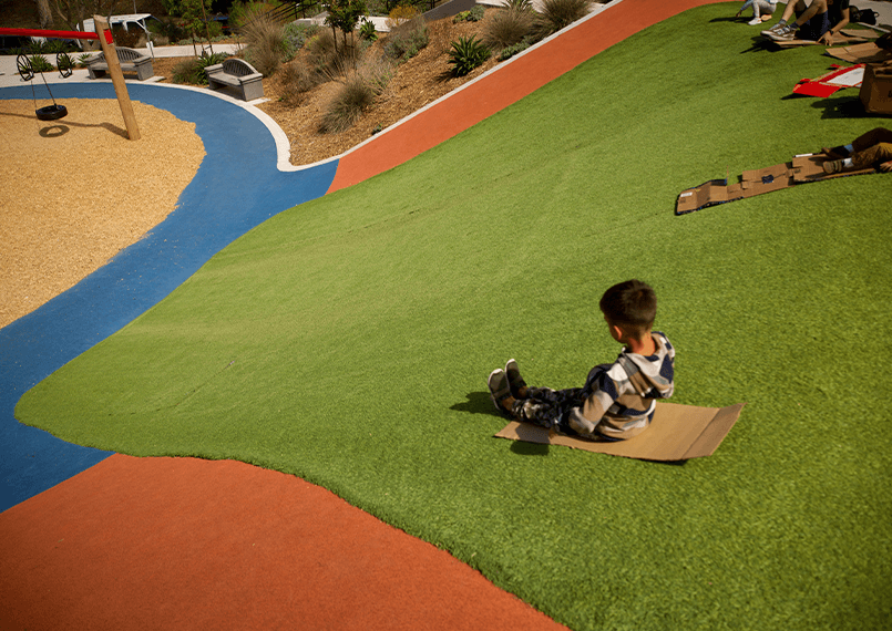 image of a child sliding down a synlawn turf hill