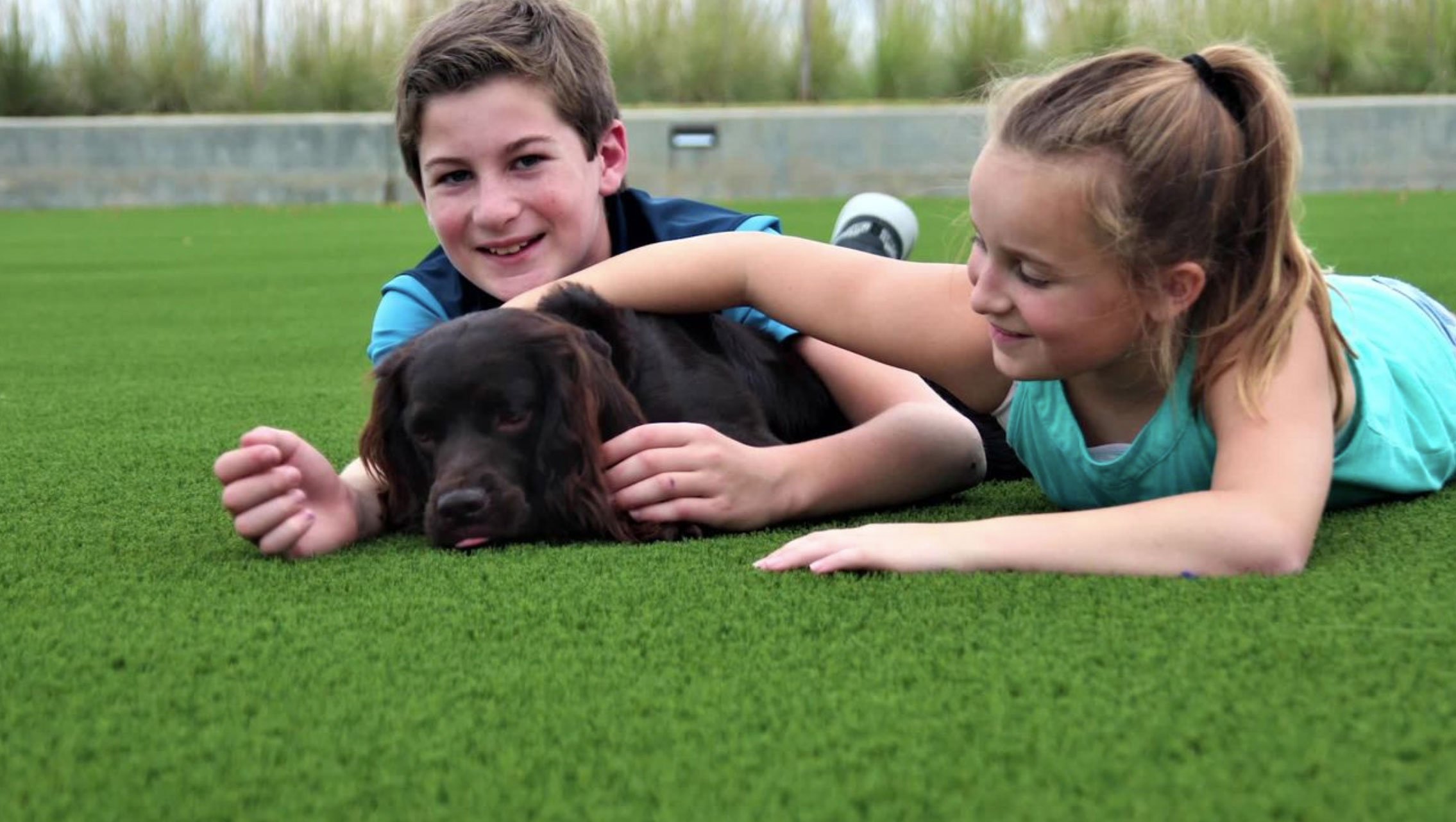 image of children playing with a dog on synlawn turf